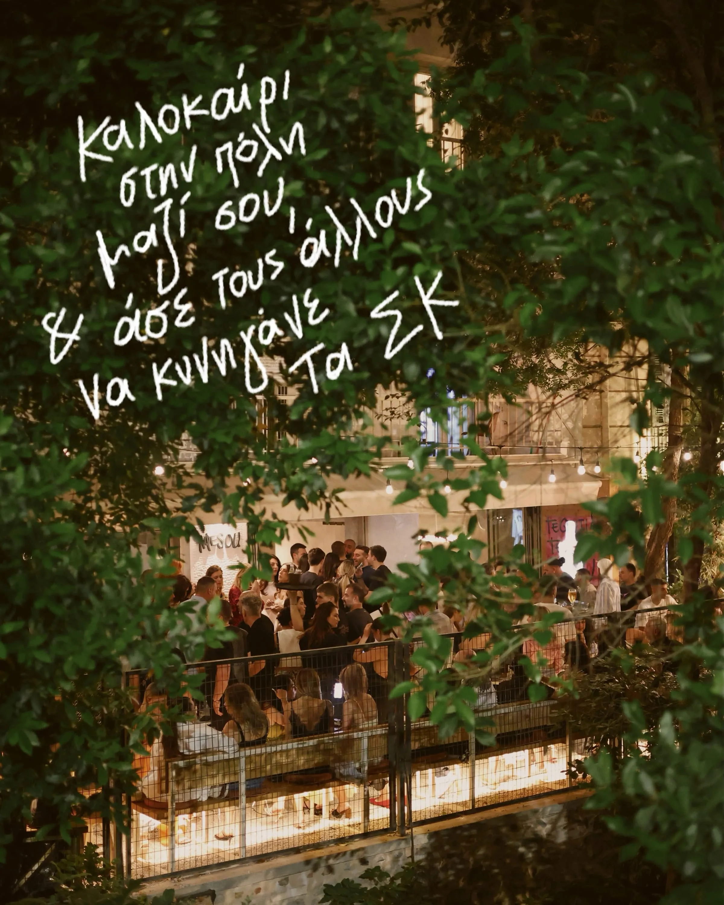 Βραδινή αυλή της Αφέσου γεμάτη κόσμο κάτω από φώτα και δέντρα